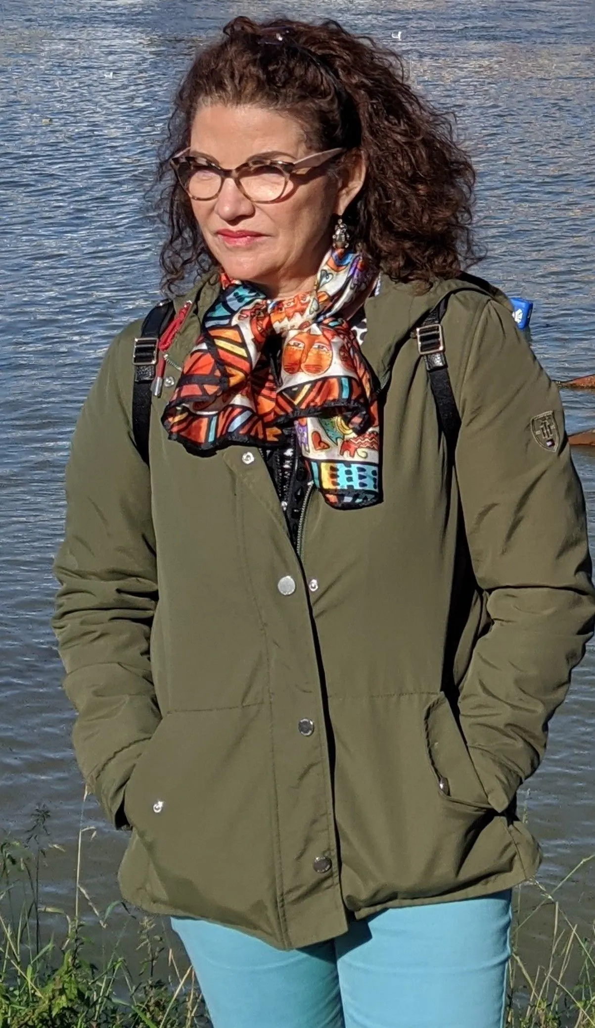Le Dr Joëlle Huth en extérieur, lunettes et foulard coloré, au bord de l’eau